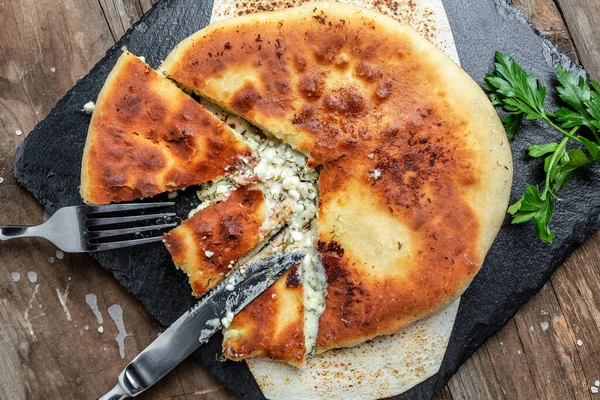 Geleneksel Osetya peynirli turta, peynirli, patatesli, otlu, süzme peynirli, biftekli, mantarlı. Ulusal Kafkas yemeği, üst görünüm.