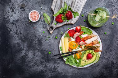 Ketogenik diyet. Yağda yumurta, avokado, çilek, ızgara tavuk fileto, peynir, fındık ve roka düşük karbonhidratlı yüksek yağlı kahvaltı, üst manzara.,