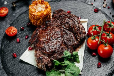 Dilimlenmiş biftek, arka planda ızgara. Restoran menüsü, diyet, yemek kitabı tarifi üst görünümü.