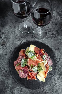 İtalyan antipastası ve kırmızı şarap. Aperatifler. Tahtada farklı antipasti geleneksel İspanyol eti atıştırmalıkları var..