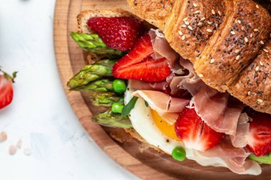 Lezzetli taze kahvaltı, ıspanak ve peynirli ızgara çörek, kuşkonmaz, jambon, jambon, jambon, jambon ve sahanda yumurta. Taze meyve suyu, dengeli diyet. metin için yer, üst görünüm.