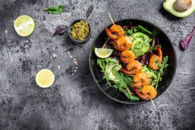 Vejetaryen sebze düşük karbonhidratlı avokado, taze salata, ızgara karides ve pesto sosu. Sağlıklı beslenme kavramı. en üstteki görünüm.