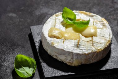 Fırında kamembert peyniri ve fesleğen yaprağı. Köy masasında ev yapımı ızgara peynir. afiş, menü, metin için tarif yeri, üst görünüm.