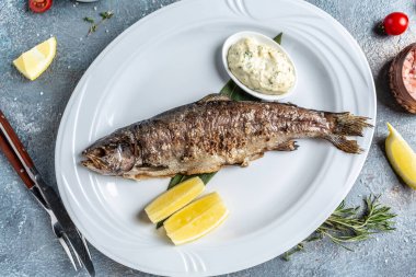 Izgara taze deniz levreği. Bitki ve limonla pişirilmiş Akdeniz balığı. afiş, menü, metin için tarif yeri, üst görünüm ,