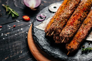 Kesme tahtası arka planında baharatlı şiş Lula kebabı. Lula kebap, geleneksel Kafkas yemeği. Uzun afiş biçimi. en üstteki görünüm.