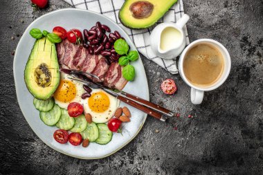Sağlıklı besleyici paleo keto kahvaltı diyeti avokado, kızarmış yumurta, pastırma, fasulye ve kahve. Ketogenik diyet konsepti. Restoran menüsü, diyet, yemek kitabı tarifi üst görünümü.