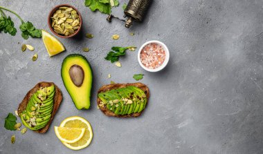 Sağlıklı avokado tostları, çavdar ekmeği ve dilimlenmiş avokado. Vejetaryen vejetaryen menüsü, tarif. Lezzetli kahvaltı ya da atıştırmalık, temiz yemek, diyet, vejetaryen yemek konsepti. en üstteki görünüm,