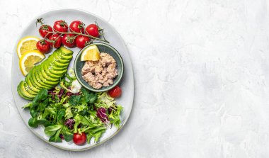 Hafif arka planda ton balığı salatası. Marul, vişneli domates, avokado ve kırmızı soğan. Temiz sağlıklı detoks yeme. Vejetaryen yemeği. Sağlıklı salata yapıyorum. en üstteki görünüm.