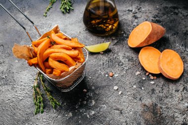 Siyah arka planda otlu patates kızartması. Uzun afiş biçimi. Üst manzara, yemek tarifi geçmişi. Kapat..