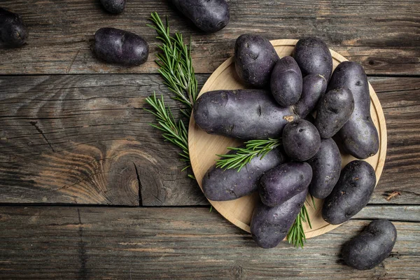 Raw purple sweet potato food . Fresh potatoes in an old sack on wooden background. Batata potato. vegan food ingredient. banner, menu, recipe place for text, top view.