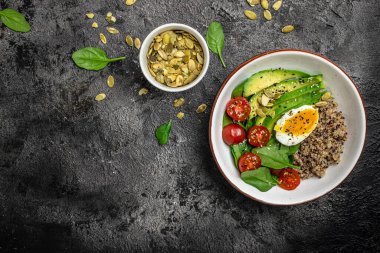 İçinde avokado, yumurta, domates, ıspanak ve ay çekirdeği olan kinoa budha kasesi. Ev yapımı yemek. Sağlıklı, temiz yemek. Vegan ya da glütensiz diyet, metin yeri, üst görünüm,