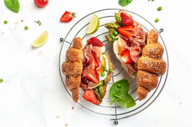 Lezzetli taze kahvaltı, ıspanak ve peynirli ızgara çörek, kuşkonmaz, jambon, jambon, jambon, jambon ve sahanda yumurta. Taze meyve suyu, dengeli diyet. metin için yer, üst görünüm.