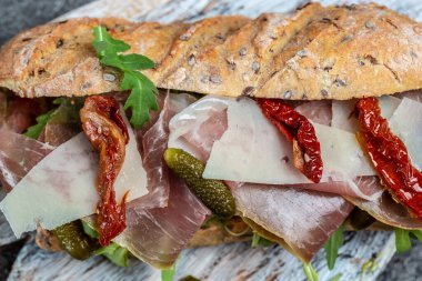 Prosciutto sandviçi, jambonlu Ciabatta, kurutulmuş domatesler, turşu, parmesan ve roka, afiş, menü, metin için tarif yeri.,