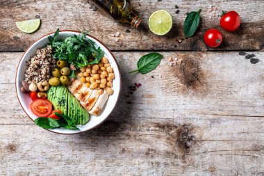 Karalahana salatası, kinoa, tavuk filetosu, nohut, avokado, ıspanak, domates kirazı, fındık roka, temiz beslenme konsepti. Uzun afiş biçimi. en üstteki görünüm.