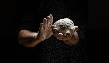 Un ve un serpintili erkek eli fotoğrafı. Ekmek pişiriyorum. Hamuru yoğurmak.