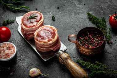 Çiğ mermer et, biftek fileminyonu. Eski et tavasında servis edilen domuz pastırmasına sarılı biftekler, yemek pişirme konsepti. Üst Manzara. metin için yer.