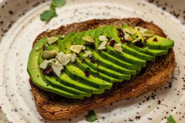 Taze yeşil Avokado sandviç çavdar ekmeği, kabak tohumu, tuz ve biber. Vejetaryen yemeği. Bitki temelli diyet. Temiz yemek. Üst Manzara. Boşluğu kopyala,