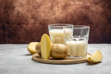 Bardakta vejetaryen patates sütü ve çiğ patates. Alternatif bitkisel süt. Süper yiyecek konsepti. Sağlıklı, temiz yemek. Vejetaryen ya da glütensiz diyet. afiş, menü, metin için tarif yeri.