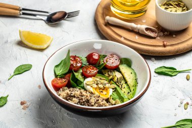 Keto diyet tabağı kinoa, avokado, yumurta, domates, ıspanak ve ayçiçeği tohumları. Sağlıklı yiyecekler, ketojenik diyet, diyet öğle yemeği konsepti, metin yeri, üst görünüm.
