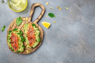 Lezzetli kahvaltı ya da somon balığı, avokado, ıspanak, fındık, ayçekirdeği, kırmızı balık ve guacamole ile tost. Sağlıklı, temiz yemek. Vejetaryen ya da glütensiz diyet. Üst görünüm, boşluk kopyala.