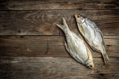 Güneşte kurutulmuş balık. Kahverengi ahşap masada stok balığı. Bira fabrikası konsepti. Kurutulmuş bira için atıştırmalık. Bira arkaplanı,