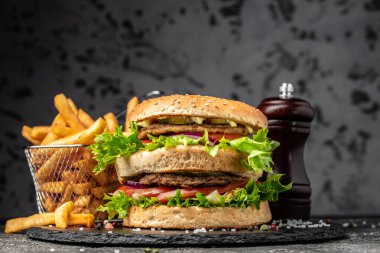 Ev yapımı hamburger, ızgara et, sebze, ahşap arka planda sos. Fast food ve abur cubur kavramı,