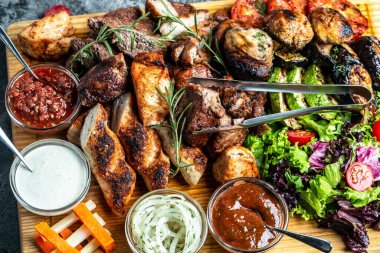 Lezzetli ızgara et ve sebze. Ahşap tabakta ızgara bbq eti ve sebzeler. Restoran menüsü, diyet, yemek kitabı tarifi üst görünümü,