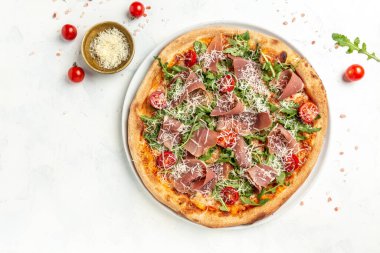Peynirli İtalyan pizzası, prosciutto, roka ve parmesan peyniri. Salamlı fırında pizza, prosciutto kırmızı sos ve peynir. Üst görünüm.