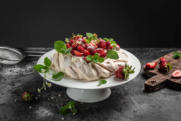 Lezzetli ev yapımı Pavlova pastası taze çilek ve krem şantili. Kadın fırıncı nefis kremalı pasta dekorasyonu, üst manzara. metin için yer,