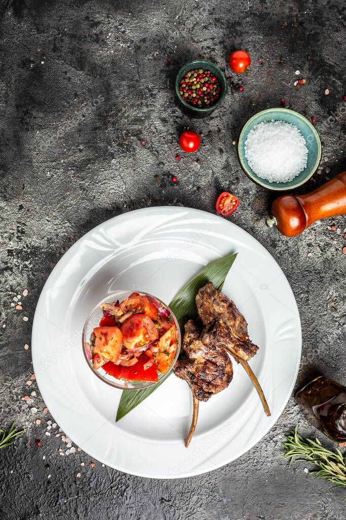 lamb chop meal with with vegetable salad with tomatoes, vertical image. top view. place for text,