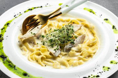 Tavuklu makarna, kremalı soslu Fettuccine Alfredo, tavuklu, parmesanlı beyaz tabak. İtalyan mutfağı. Restoran menüsü, diyet, yemek kitabı tarifi üst görünümü.