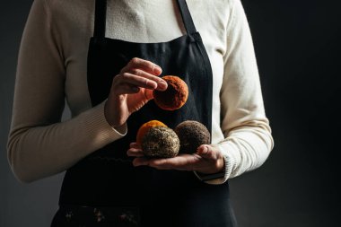 Peynir üreticisi, Belper Knolle peynirini küçük toplar şeklinde kontrol ediyor. Sert peynir tutan kadın elleri. Uzun pankart biçimi.