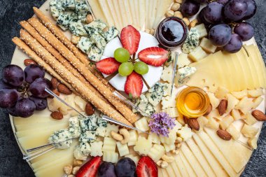 Antipasto tabağı, çeşitli yumuşak ve sert peynirlerden oluşan Antipasto Peynir tabağı. İspanyol manchego peyniri, aperatif parti konsepti, afiş, menü, tarif üst görünümü.