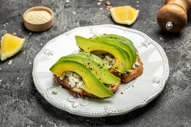 Avokado çavdar ekmeği, dilimlenmiş avokado, kahvaltıda ya da öğle yemeğinde kabak çekirdeği. Vejetaryen sandviçler. Sağlıklı, temiz yeme konsepti. Vejetaryen ya da glütensiz diyet. en üstteki görünüm.