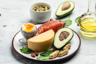 Düşük karbonhidratlı ürünleri yüksek proteinli ve iyi yağ kaynaklı yapın. Sağlıklı yağlar, hafif arka planda kilo vermek için temiz yiyecekler, keto ya da ketojenik diyet, yemek tarifi geçmişi. Kapatın. en üstteki görünüm.