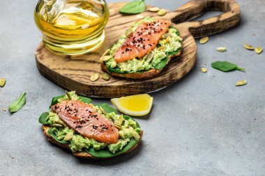 Avokadoo, somon ve ıspanak, fındık ve ayçekirdeği ile tost. Sağlıklı, temiz yemek. Vejetaryen ya da glütensiz diyet. Üst görünüm, boşluk kopyala.