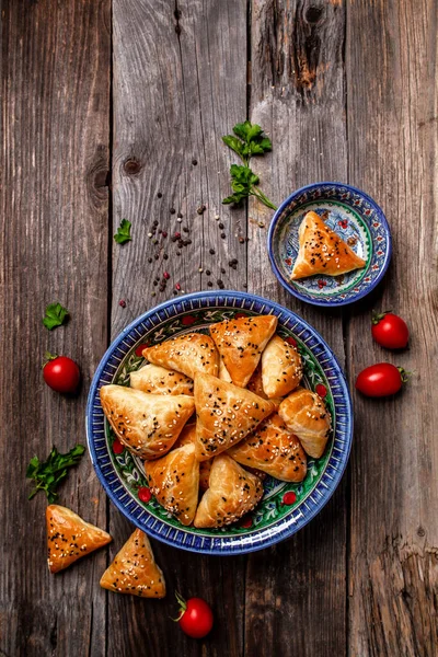 Traditional Indian cuisine samosas baked pastry with savoury filling, popular Indian snacks with spices on rustic background, vertical image. top view. place for text,