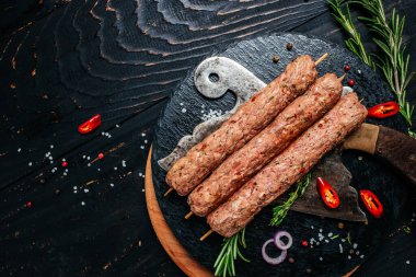 Kesme tahtası arka planında baharatlı şiş Lula kebabı. Lula kebap, geleneksel Kafkas yemeği. Uzun afiş biçimi. en üstteki görünüm.