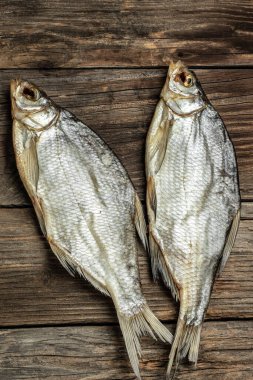 Güneşte kurutulmuş balık. Kahverengi ahşap masada stok balığı. Bira fabrikası konsepti. Kurutulmuş bira için atıştırmalık. Bira arkaplanı,