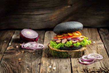 Köy ahşap bir masada servis edilen sığır burger, marul, mayonez ve ketçap karışımı. Fast food ve abur cubur kavramı.