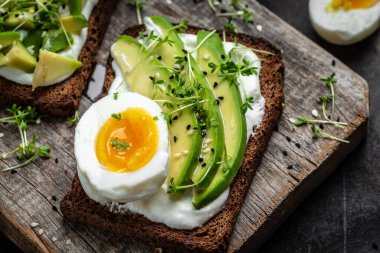 Avokadolu iki tost, haşlanmış yumurta ve mikroyeşil. diyet ya da vejetaryen yemeği. Üst görünüm.