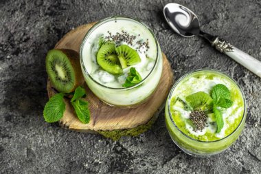 Chia pudingi, nane ve kivi. Laktozsuz yoğurt. Lezzetli kahvaltı ya da atıştırmalık, temiz yemek, diyet, vejetaryen yemek konsepti. en üstteki görünüm.