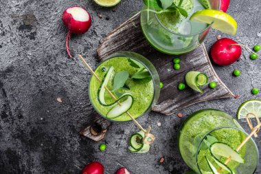 Bir bardak taze yeşil Smoothie ile organik yeşiller ve limonlar, detoks smoothie, yeşil bezelye, salatalık, ıspanak ve limon. Sağlıklı Detoks İçeceği.