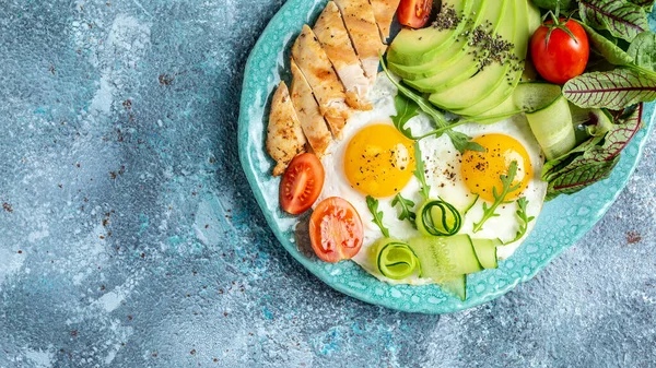 Sağlıklı kahvaltı. Tavuk ızgara fileto salata taze domates, salatalık, yumurta ve avokado. Keto Paleo diyet menüsü. en üstteki görünüm.