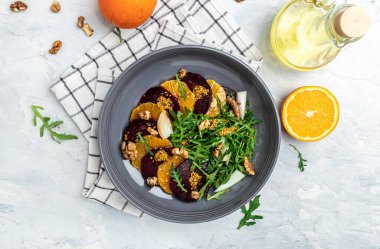 Roka, portakal ve cevizli sağlıklı pancar salatası. Temiz yemek, diyet, vejetaryen yemek konsepti. afiş, menü, metin için tarif yeri, üst görünüm.