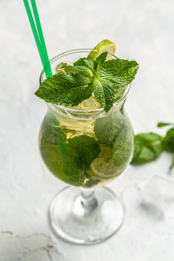 Limonlu mojito kokteyli ve koyu arka plan dikey görüntüsünde viski bardağında nane şekeri. metin için yer.