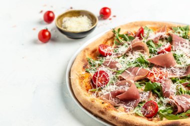 Peynirli İtalyan pizzası, prosciutto, roka ve parmesan peyniri. Salamlı fırında pizza, prosciutto kırmızı sos ve peynir. Üst görünüm.