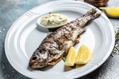Izgara taze deniz levreği. Bitki ve limonla pişirilmiş Akdeniz balığı. afiş, menü, metin için tarif yeri, üst görünüm ,