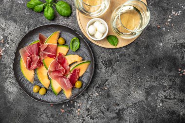 Jambonlu kavun, jambonlu kavun ve bir bardak şaraplı yeşil fesleğen yaprağı. Lezzetli süper yemek salatası, geleneksel İtalyan aperatifi. metin için yer,