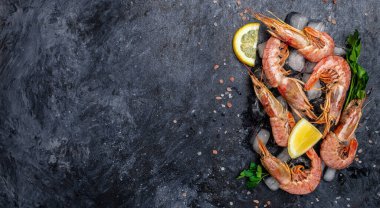 Deniz ürünleri. Tuzlu ve limonlu kırmızı Arjantin karidesleri, arka planda vahşi karidesler, okyanus karidesleri. afiş, menü, metin için tarif yeri, üst görünüm.